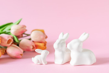 Easter holiday decorations on pink background with spring flowers, festive greeting card