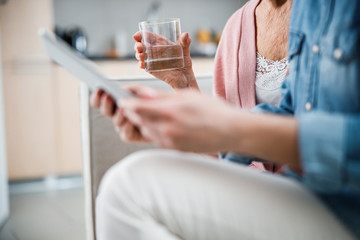 Old lady hand holding glass of water