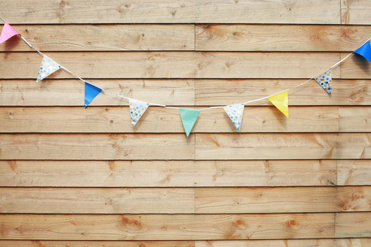 Wooden planks wall background with a birthday party flags slinger