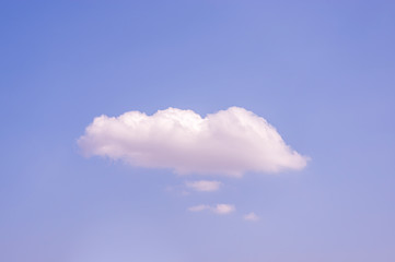 Blauer Himmel bei Sonnenschein mit einer großen weißen Wolke und mehreren kleinen weißen Wolken darunter wie Gedankenwolken oder Sprechblasen mit viel Textfreiraum