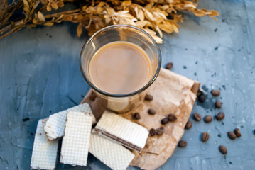 Coffee with milk in a glass and gluten-free waffles made from rice flour. Wafers with chocolate filling, on a gray background.Nutrition concept for people with gluten intolerance.