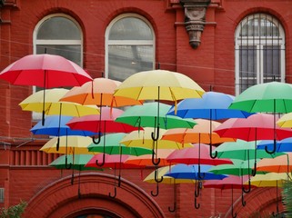 Regenschirme hängen vor Fassade