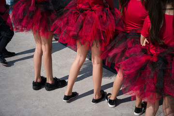legs of children in red dresses