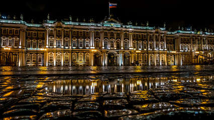 Fototapeta na wymiar Wet Palace Square and the Winter Palace building at night.