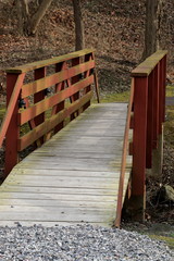 The red footbridge crosses the stream.
