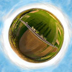 Little Planet (arial) of country road leading through spring landscape in Franconia, Germany at low standing sun.