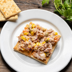 Tuna salad with mayonnaise on wooden background