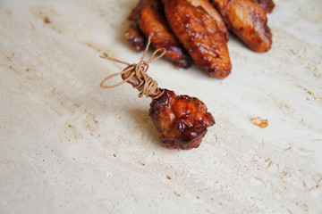  fried chicken wings with spices and herbs, served on a marble table.