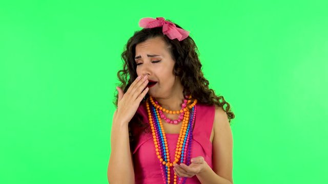 Girl claps her hands indifferently. Green screen at studio.