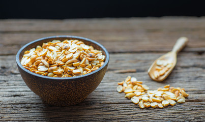 Roasted peanuts in bowl with wooden background