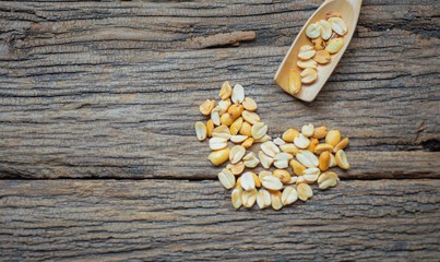 Roasted peanuts in bowl with wooden background