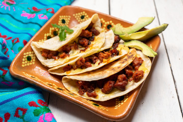 Mexican quesadillas with chorizo on white background