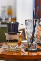 Vietnamese condensed milk coffee with dripping filter and ice