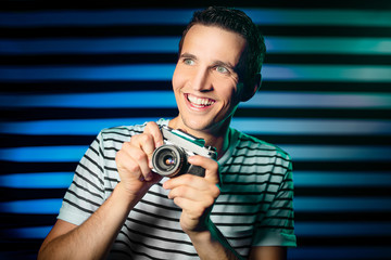 young happy photographer while photoshoot with analog camera