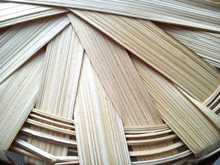 part of a basket woven from a vine in warm beige tones. A basket made of wood chips or bast
