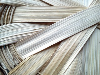 part of a basket woven from a vine in warm beige tones. A basket made of wood chips or bast