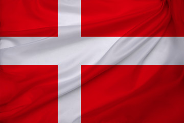 Fototapeta premium beautiful photo of the colored national flag of the modern state of Denmark on textured fabric, concept of tourism, emigration, economics and politics, close up