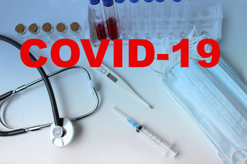 medical laboratory test tube with blood inside, stethoscope, syringe, protective masks, concept of...