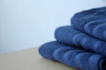 pile of clean terry cotton blue towels, close-up, on a light background, copy space, concept of cleanliness, bath procedure, spa