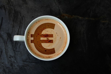 white cup with cappuccino and foam in the form of a picture of euro