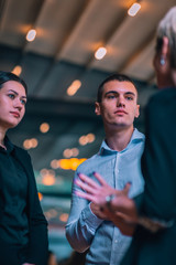Group of three young entrepreneurs discussing business ideas in front of an office.
