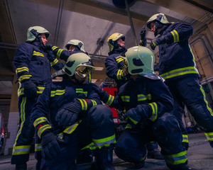 Portrait of group firefighters in front of firetruck inside the fire station