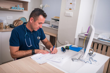 Fototapeta premium Male serious caucasian doctor sitting in his office alone and thinking about the surgery he performed.