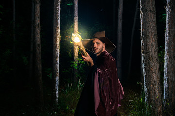 Young male cosplayer wearing sorcerer robes in the forest