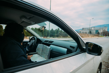 Bank robbers with their masks on pointing at the map prepared for robbing the bank,sitting in the...