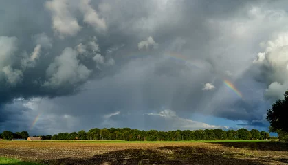 Fotobehang impressive scenic dramatic grey cloudy sky with rainbow over a stubblefield in the region "Goldenstedter Moor" near Vechta, Lower Saxony (Germany) during autumn © heidepinkall