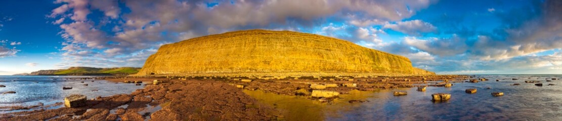 Fototapeta na wymiar Kimmeridge panorama - glowing golden cliffs illuminated in the sunshine
