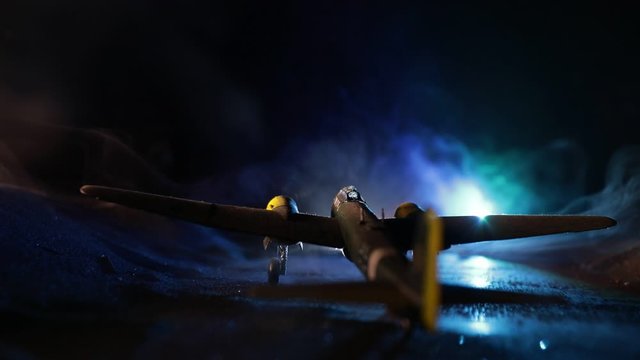 German Junker (Ju-88) night bomber at night. Artwork decoration with scale model of jet-propelled plane in possession. Toned foggy background with light. War scene. Selective focus