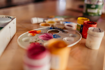 Artist paint brushes and palette on wooden background