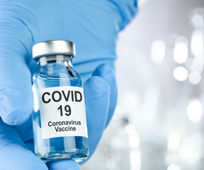 Healthcare cure concept with a hand in blue medical gloves holding Coronavirus, Covid 19 virus,...