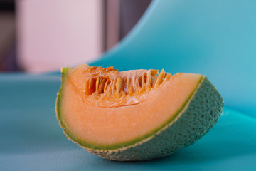 Fresh cantaloupe slice on a aquamarine background