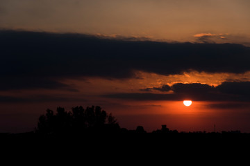 Dramatic and beautiful sunset, cloudy sky with parts of intense orange color