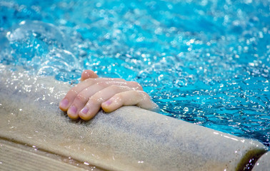 Fototapeta premium Hand reaches out of a swimming pool