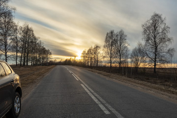 Fototapeta premium Suburban road goes into the distance at sunset