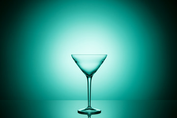 Empty martini glass. Beautiful turquoise gradient background. 