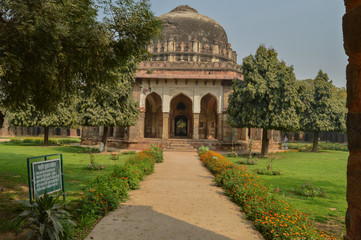 Obraz premium A Tomb of sikandar lodhi monument at lodi garden or lodhi gardens in a city park from the side of the lawn at winter foggy morning.
