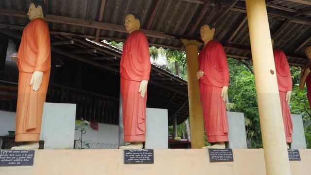 4k dolly video of buddhist monks statues standing in row at the buddhist temple
