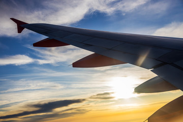 Silhouette of the airplaine - dramatic sunset sky - travelling by air on holiday