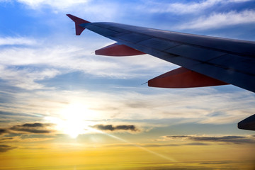 Silhouette of the airplaine - dramatic sunset sky - travelling by air on holiday