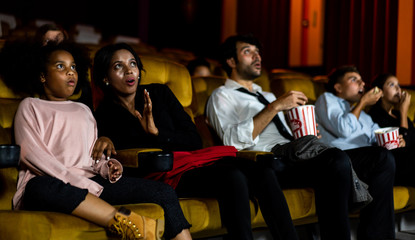 Shocked audience watching a horror movie in the cinema