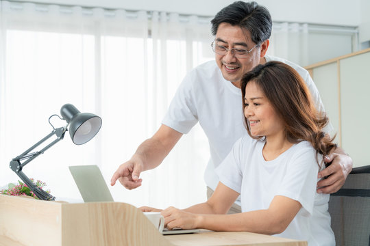 Happy Asian senior couple having good time at home. Old people retirement and healthy citizens elderly concept.