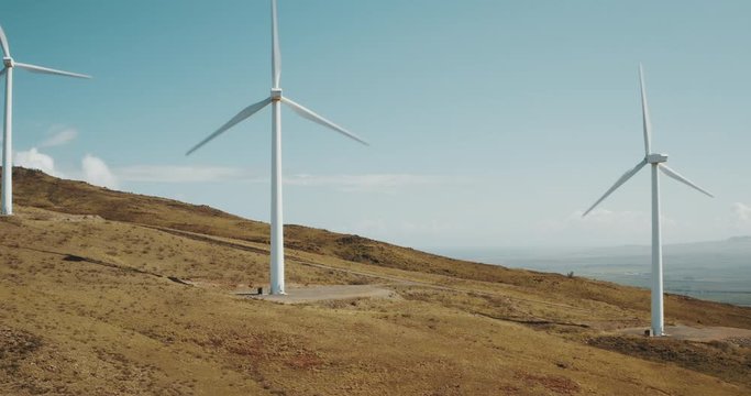 Aerial view of a row of wind turbines spinning on a hill, new types of energy generation for a cleaner and greener renewable energy future