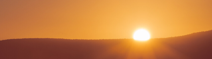 sunrise over the forested mountains