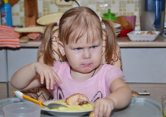 little girl eats in the kitchen