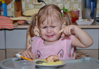 little girl eats in the kitchen