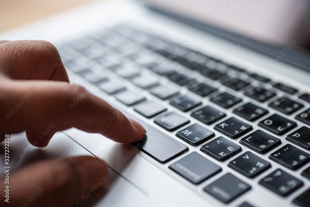 Poster shopping online. the finger pressed down on the space bar key of the notebook computer keyboard. con